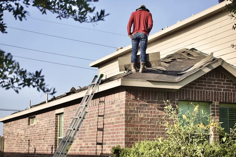 Professional roofer working on a residential roof in North Carroll Farms